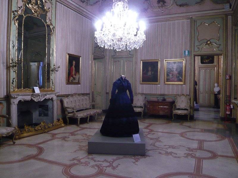 A dress inside of a palace room in a converted palace turned into a fashion museum in Milan Italy