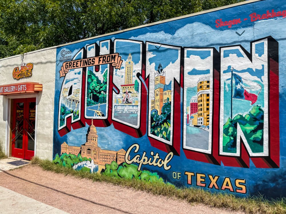 Famous Austin mural that reads "Greetings from Austin Capital of Texas" with cityscape drawn in the words in a realistic way