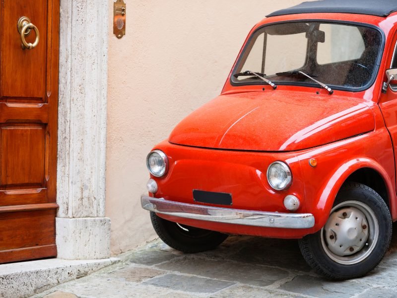 red vintage fiat next to a door in Tuscany italy