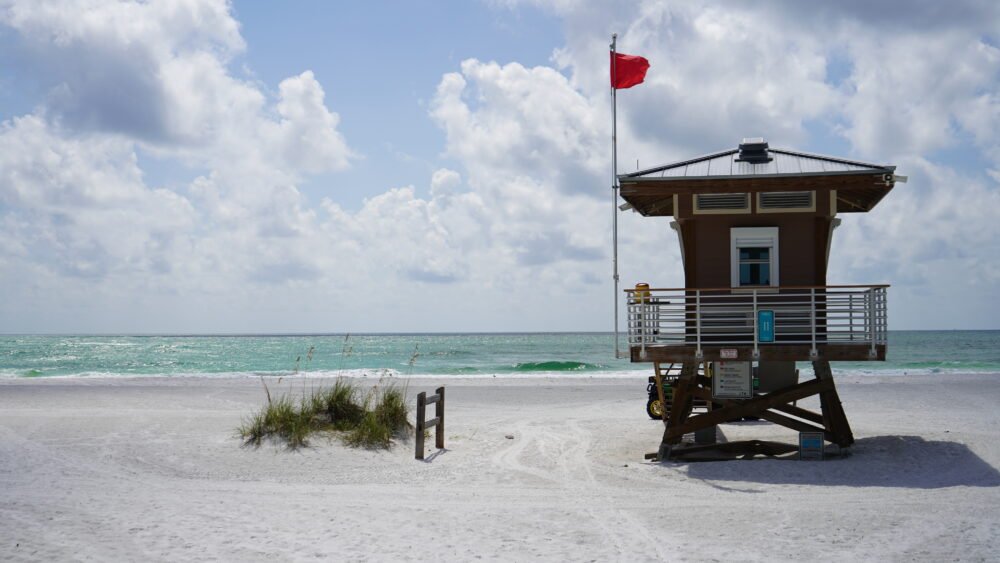 Lifeguard station at Anna Maria Island with sea grass, white sand, and clear waters