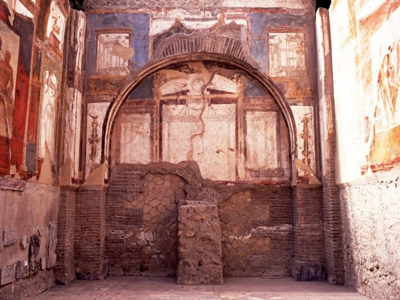 Interior fresco paintings in brilliant colors inside an ancient villa in Herculaneum, well preserved through time.