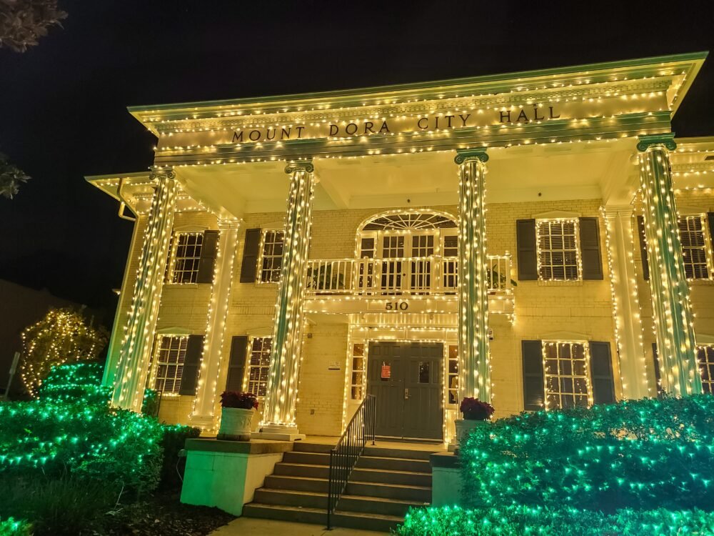 Christmas lights on Mount Dora city hall in all gold and green lights on the bushes