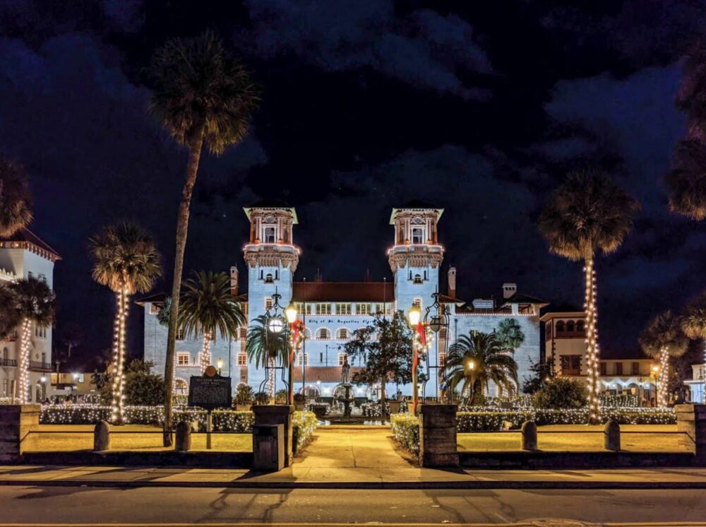 View of colonial St Augustine architecture at night with palm trees lit up with Christmas lights