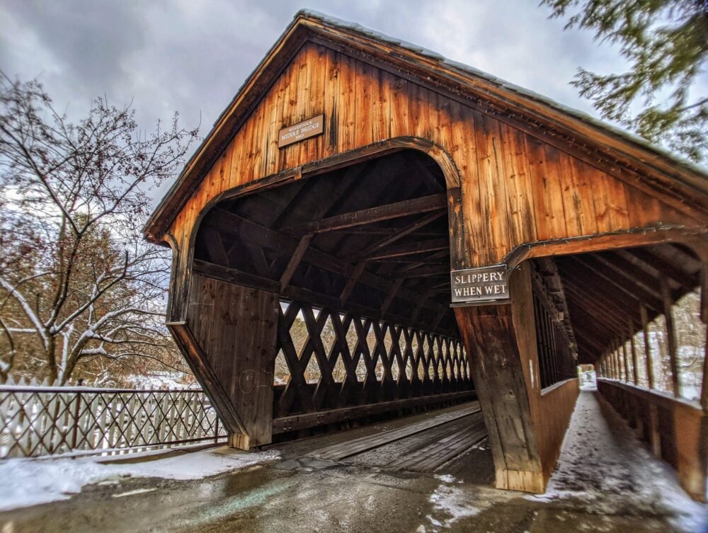 the famou smiddle covered bridge in woodstock vermont with snowy pathways