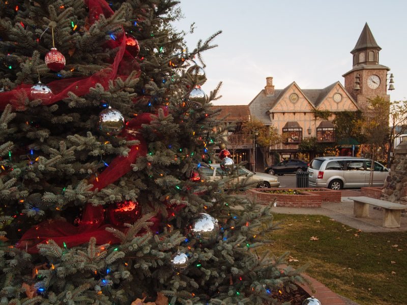 view of christmas tree with ornaments in front of the clocktower and typical european style architecture in solvang california