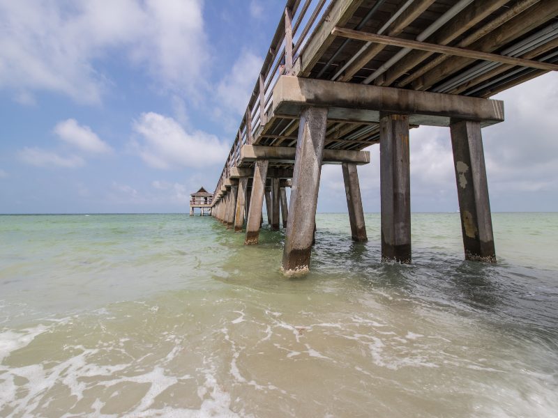 Wooden pier over clear water in Naples Florida a wonderful winter getaway in the US for warm weather