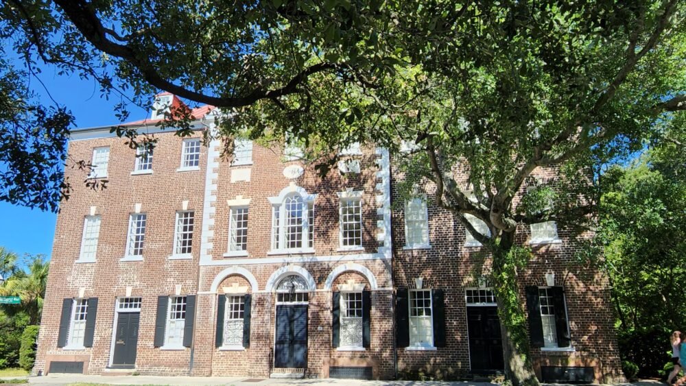 Brick building in Charleston with beautiful oak tree in front on a sunny day