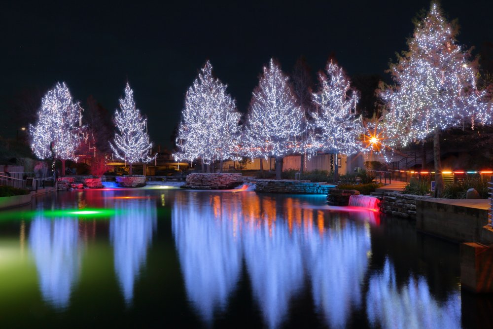 Lit up christmas trees and rainbow colors around the riverwalk area