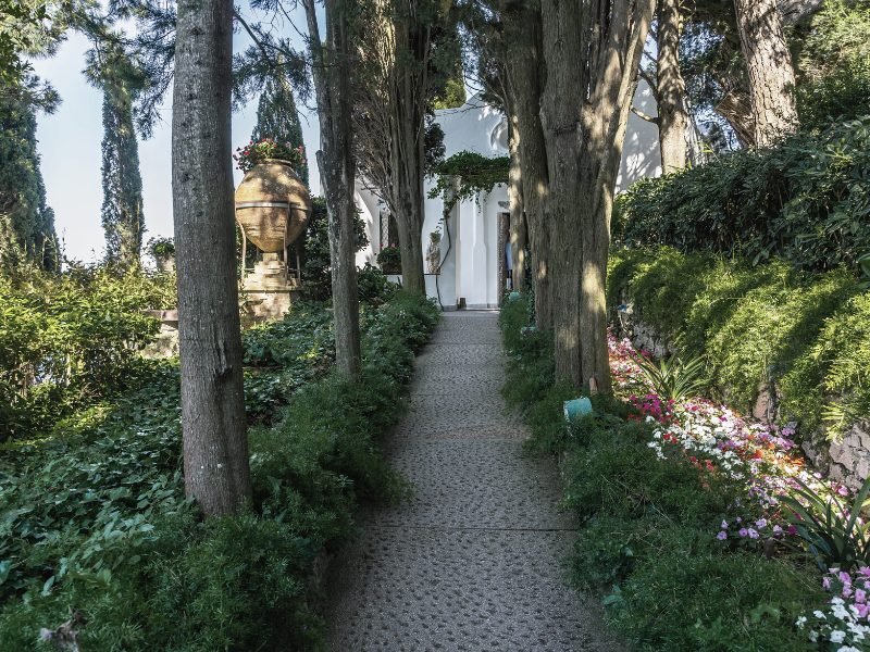 The grounds of Villa San Michele, overgrown with lots of lush greenery, with the sea distant in the horizon