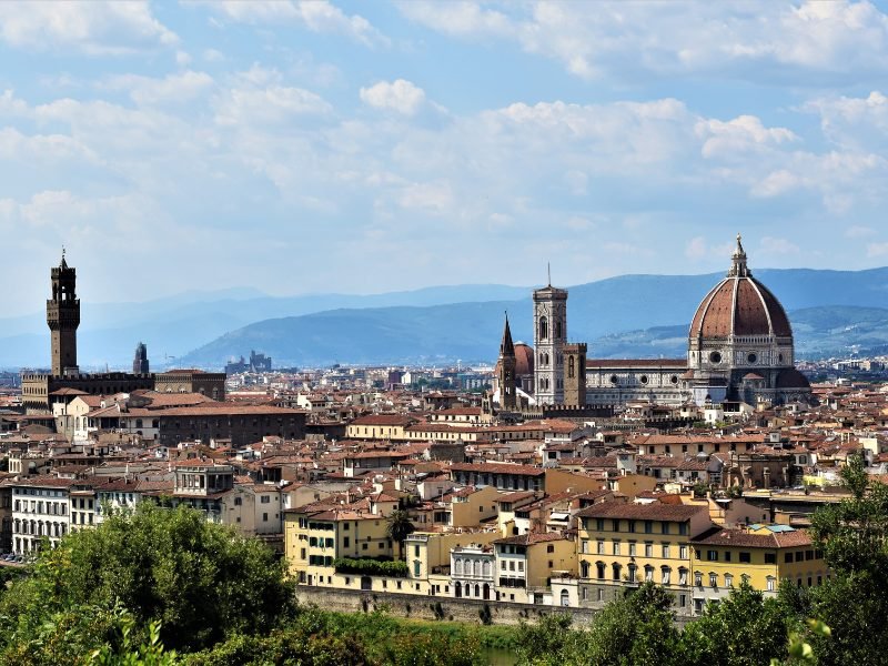 View of the cityscape of Florence, including the Duomo, the Giotto Tower, and the Old Palace from the other side of the Arno river, in Oltrarno