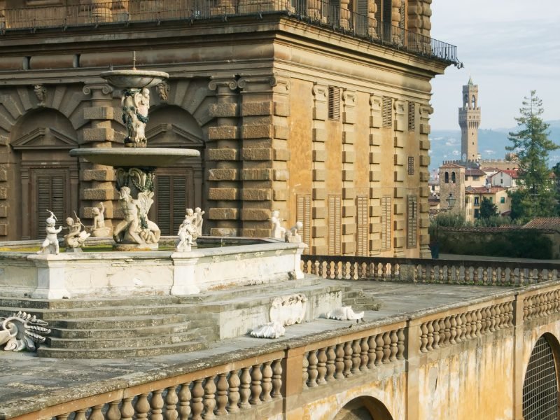 Fountain in front of Pitti Palace with view of Florence's cityscape in the background below it