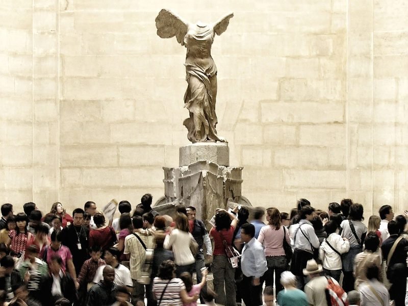 A large crowd around the Winged Victory of Samothrace, a beautiful headless and armless statue with wings - but you will find fewer crowds in other areas of the museum!