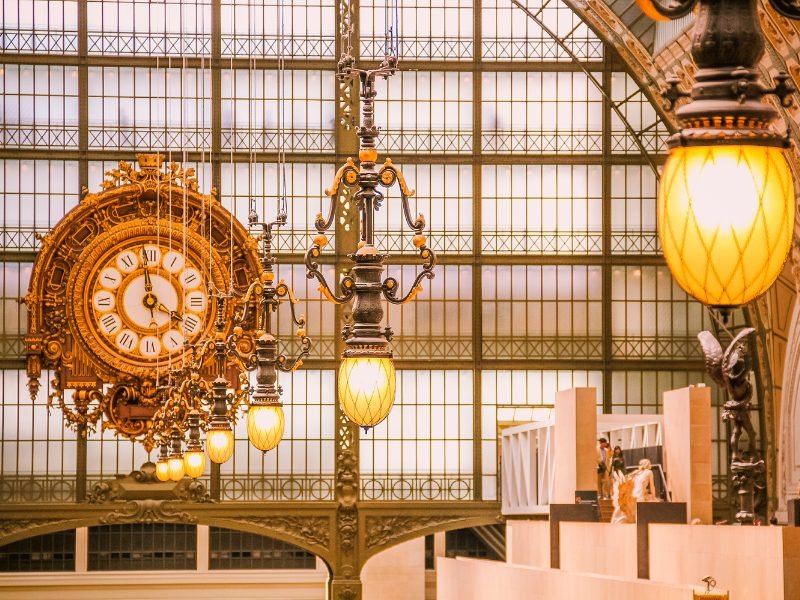 The old gold clock in the Musee d'Orsay a former train station turned into an art musuem, with beautiful light fixtures and an incredible interior architecture