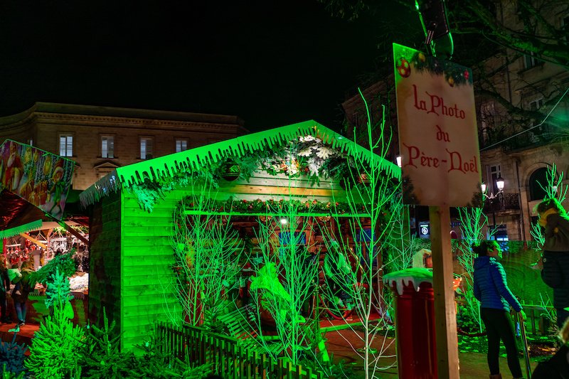 green tinted and lit up christmas market booth where it says la photo de pere noel 
