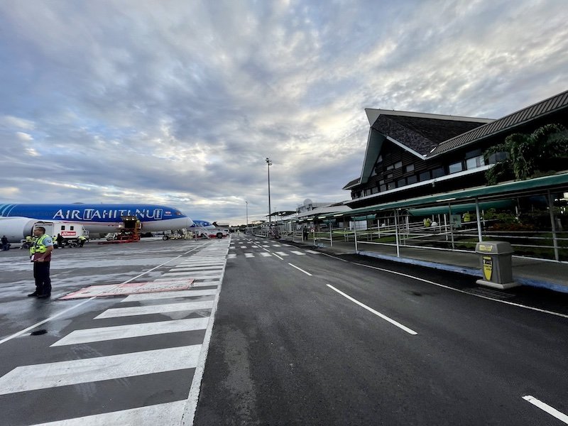 Disembarking the plane in Tahiti, an Air Tahiti Nui plane in the distance