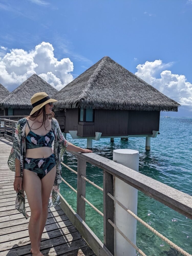 Allison standing outside the overwater bungalows at the Intercontinental Tahiti with blue water below her