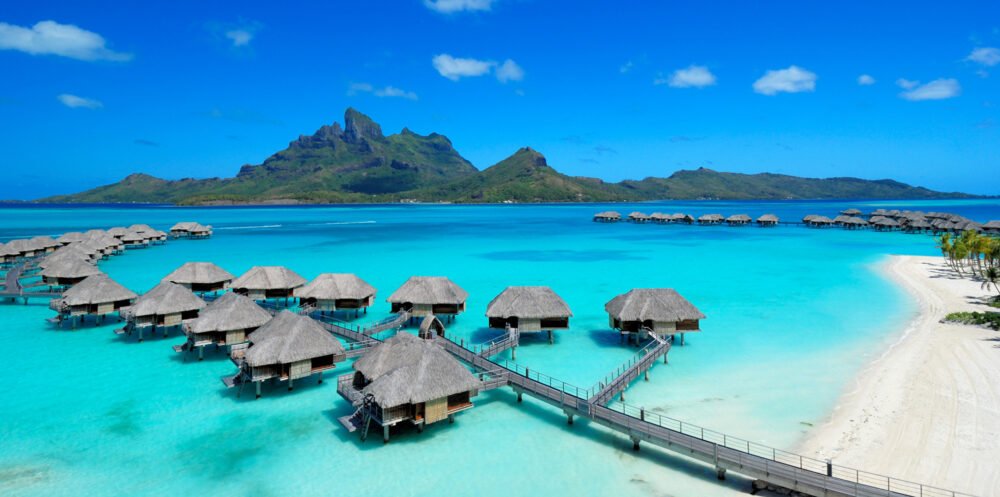 Overwater bungalows in Bora Bora with view of mountains behind it