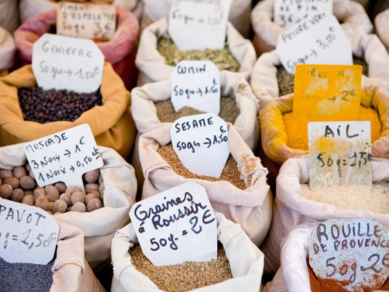 Different spices like paprika, etc in bags with prices and names written in french