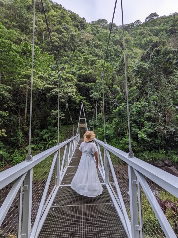 White cover up fanning out as person is spinning crossing a suspension bridge