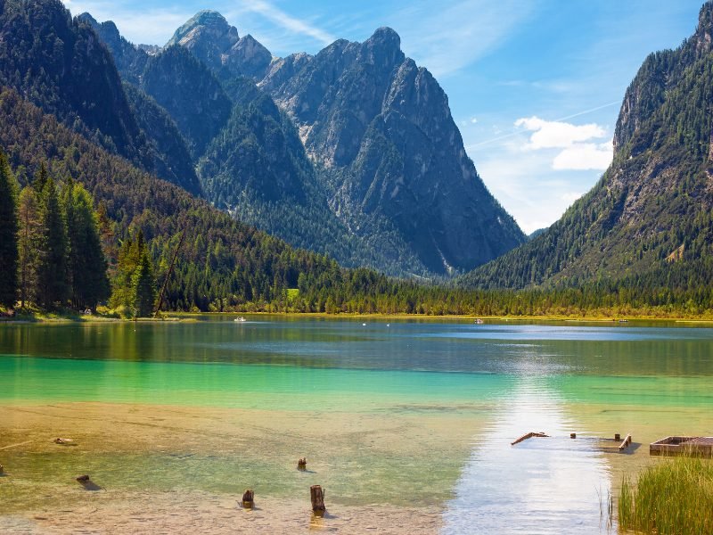 Greenish blue clear water in a lake with still water and mountains 