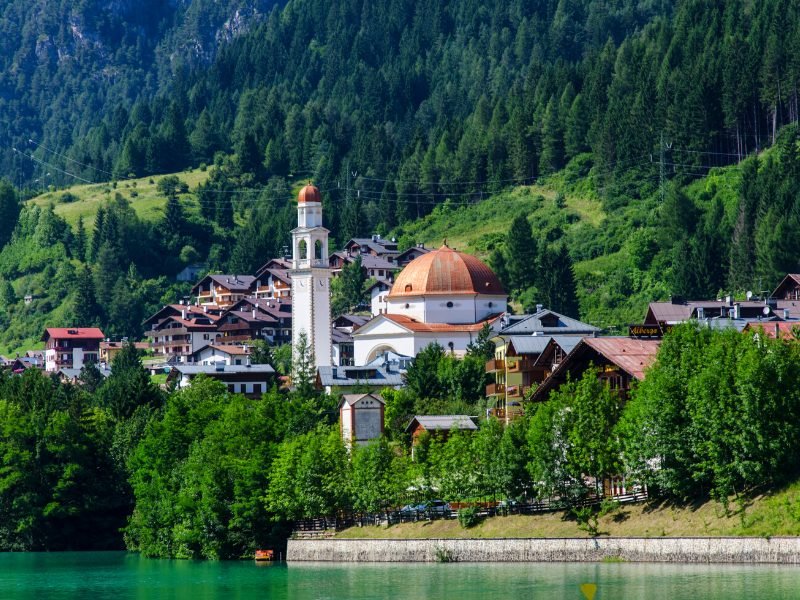 Aurora town with rounded dome church and belltower and houses on the shore