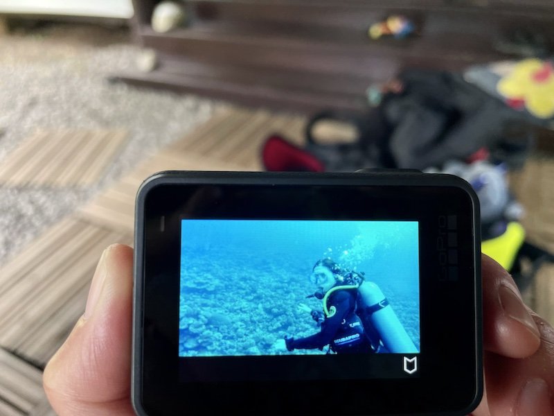 A GoPro shot of a diver underwater shown on the screen of the GoPro