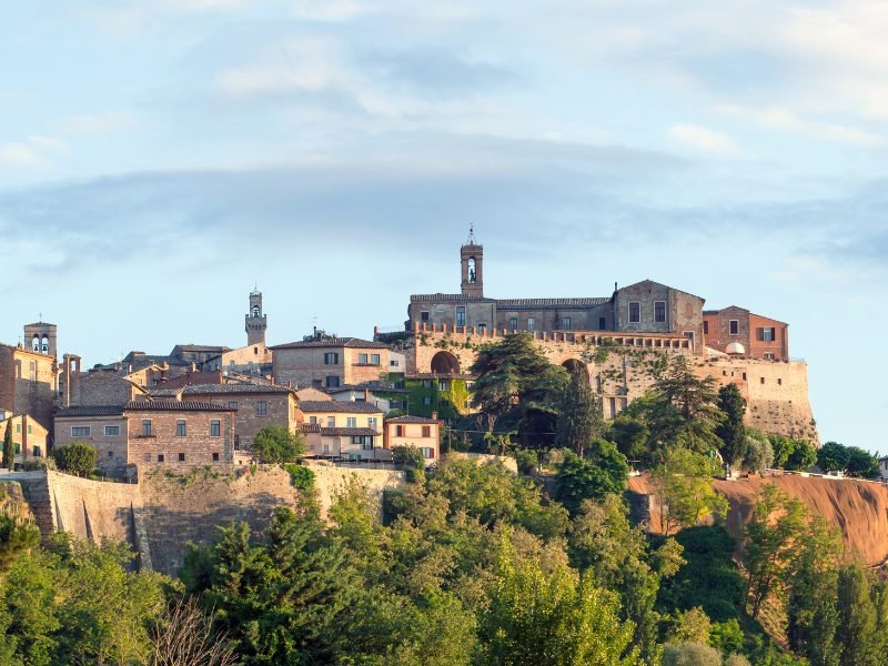 The hilltop town of Montepulciano in Tuscany, with city walls, bellltower, church steeples, making up the skyline