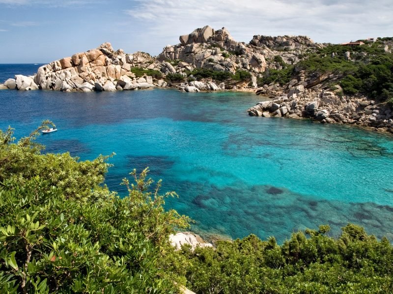 The beautiful turquoise blue waters of Sardinia with rocks both above and underwater