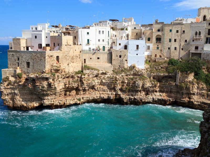 The azure waters of the Adriatic Sea as seen from the Puglian town of Polignano a Mare with whitewashed houses on a cliff