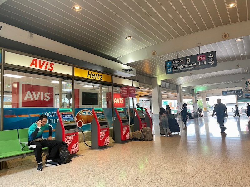 Car rental area in Faaa Airport with services like Avis, Hertz, etc. 