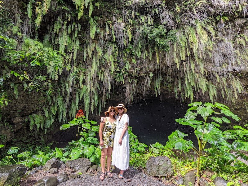 Allison and her partner at the grottoes of Tahiti with waterfall in background