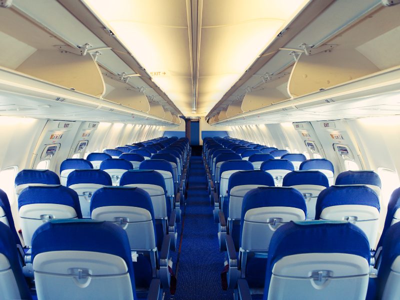 The interior of a plane with no one in it and the overhead bins clear