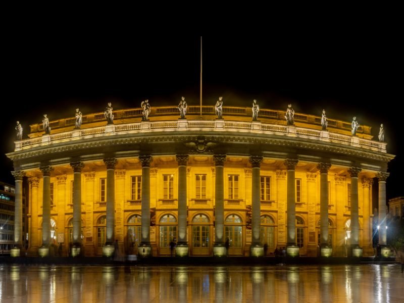 the opera house all lit up in bordeaux at night
