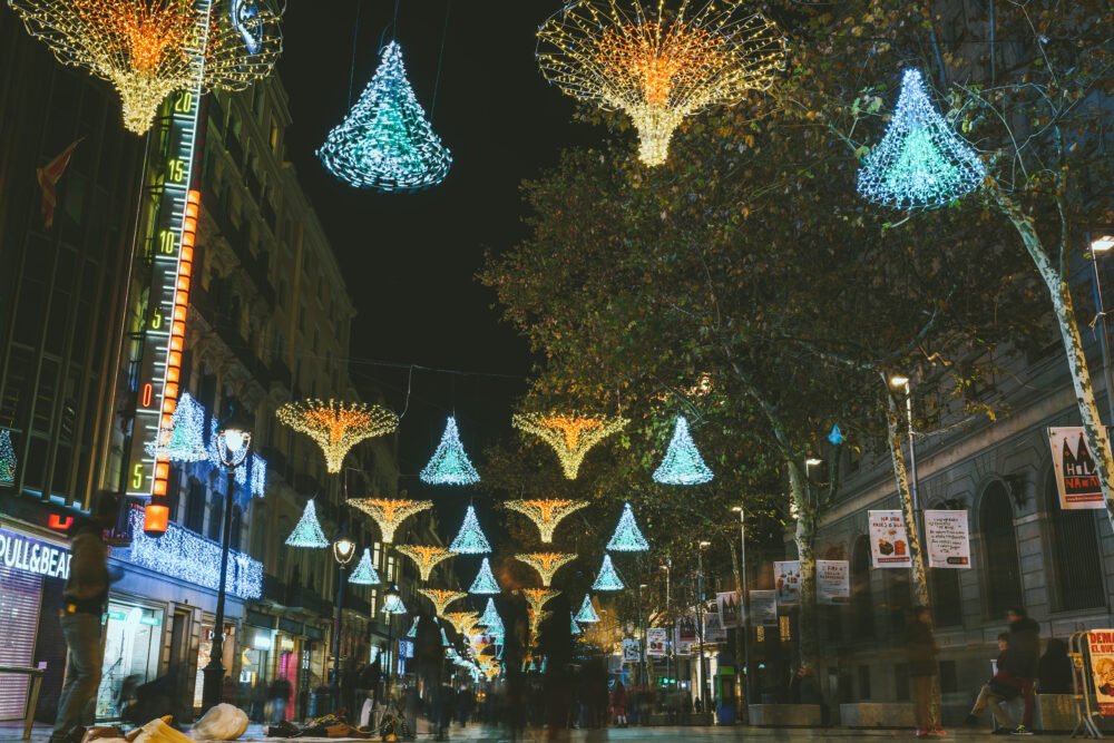 Walking down la Rambla with Christmas decorations and lights and people out and about on the streets