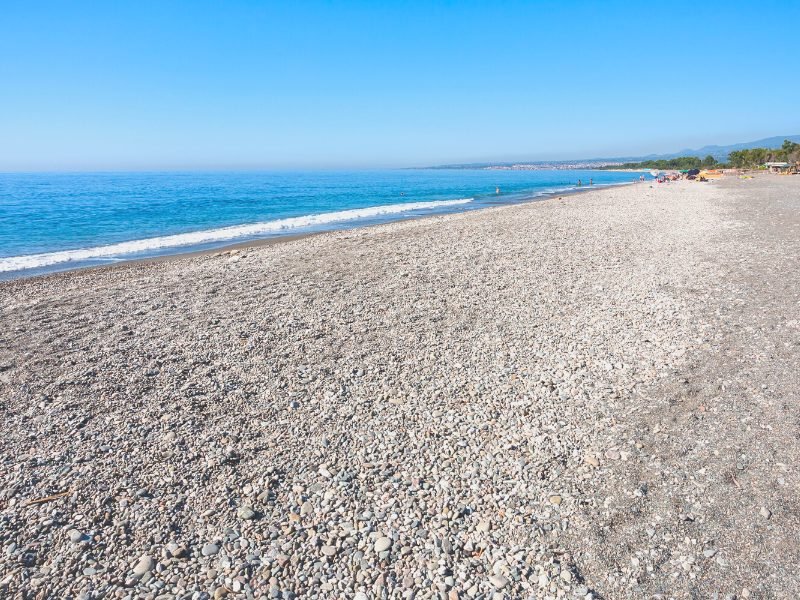 View of a pebble beach looking out onto a stunning azure sea