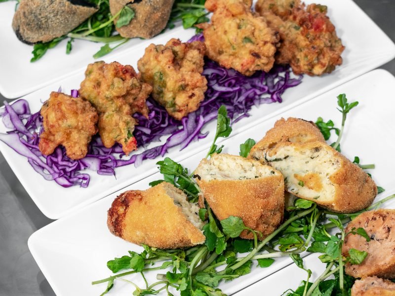 Variety of different portuguese tapas called petiscos, fried fritters, meatballs, sausage and similar small bites