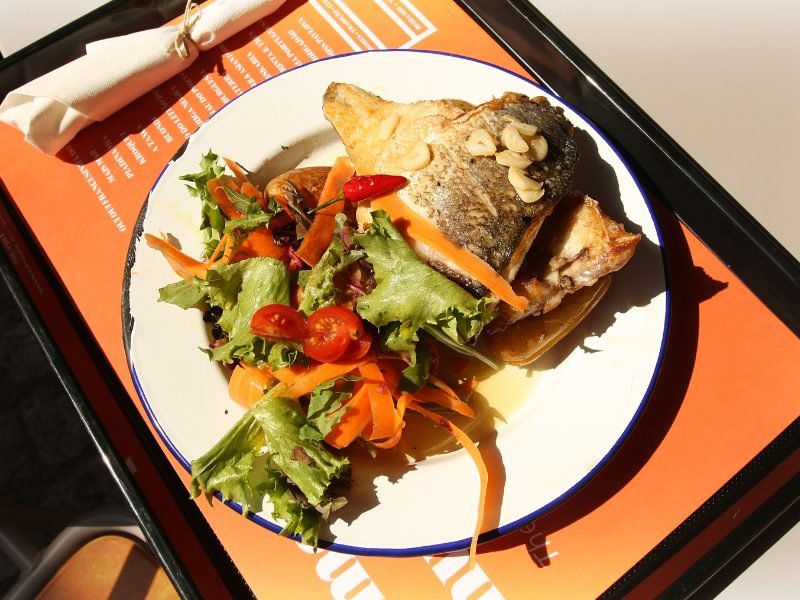 Fish with skin on, salad with tomato and carrot at an outdoor portuguese restaurant