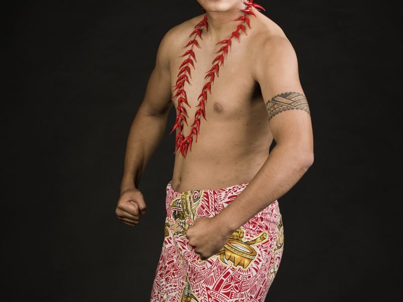 Polynesian man wearing a pareu with a polynesian arm band tattooed on him