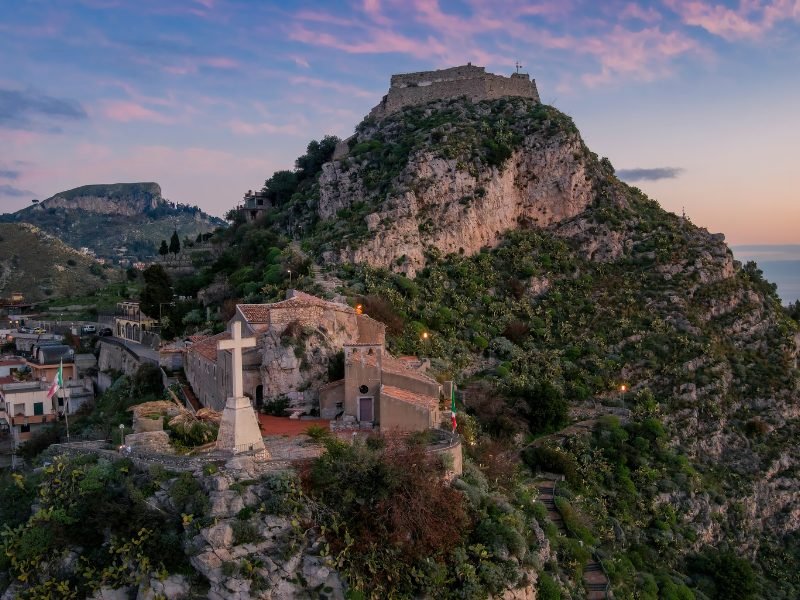 The Taormina Castle seen at sunset from the distance, the church of Madonna in the rocks also visible