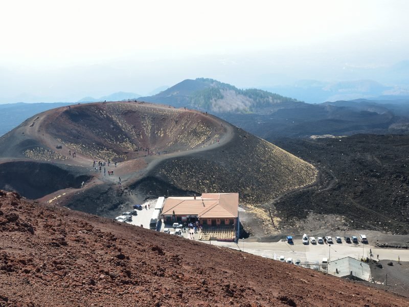 View of the Sapienza Refuge with a parking lot and small restaurant with stunning hike and views below it