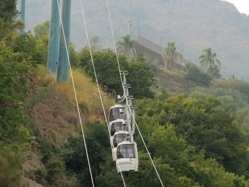 A series of four white cable cars in Taormina Sicily leading up to the mountain to the beach