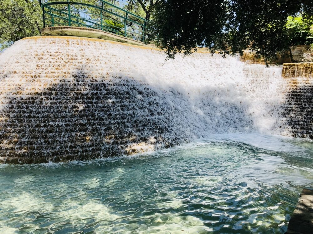 A cascading manmade waterfall in a san antonio park on a sunny day