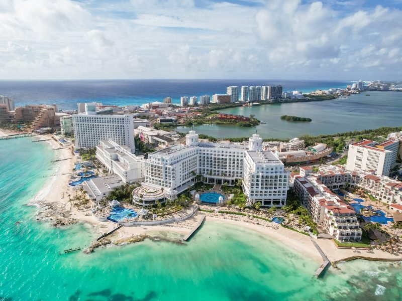 Cancun's hotel area with white sand beaches and large hotels and pools, viewed from an aerial angle