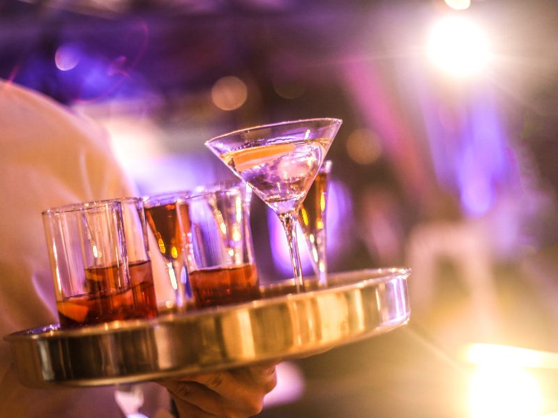 Cocktails and drinks on a tray in a bar in Cancun with a waiter holding the tray