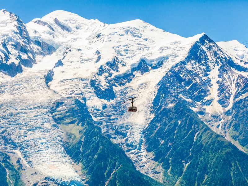 View of the Le Brevent cable car passing in front of Mount Blanc mountain covered In snow