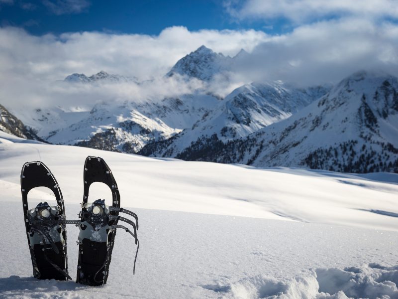 Snowshoeing in the Alps near Chamonix, two snowshoes sticking out of the snowy with an alpine snowy background