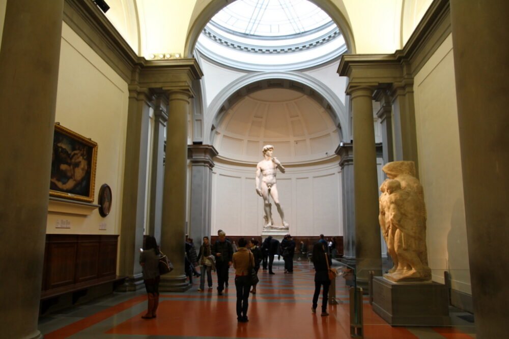 People looking at the Statue of David in the Academia Gallery