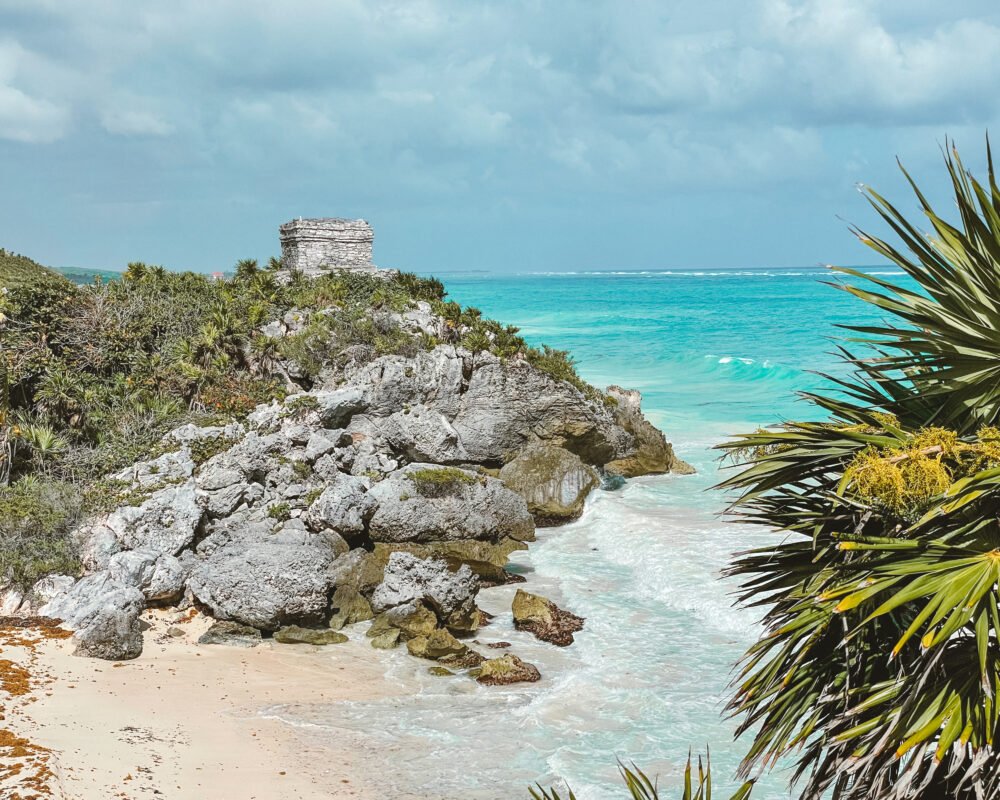Brilliant turquoise waters of Tulum's coastline with the ruins above the sea