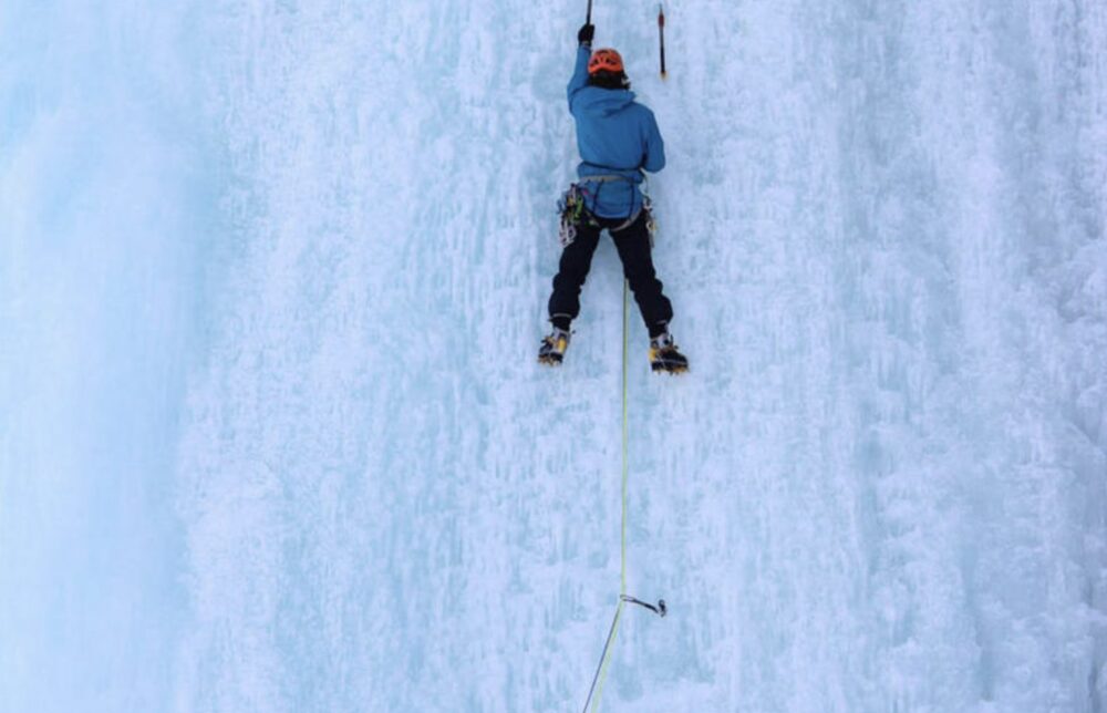 A person ice climbing up an ice wall in Chamonix area