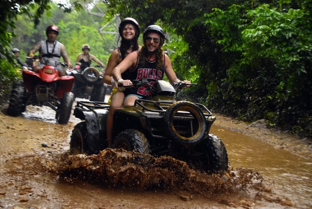 People enjoying an ATV ride through the mud while traveling in Riviera Maya